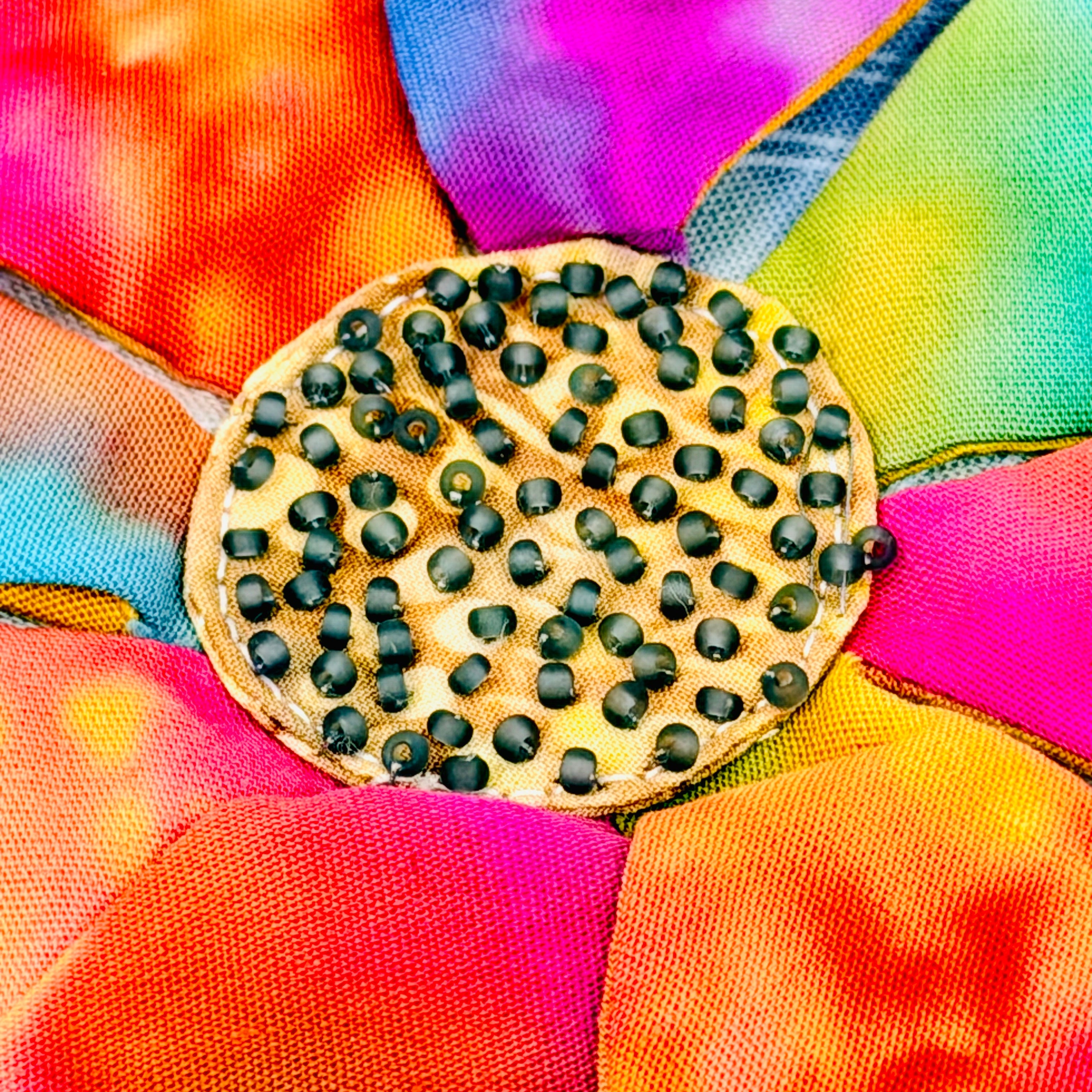 Colorful fabric flower with a circular wooden bead in the center