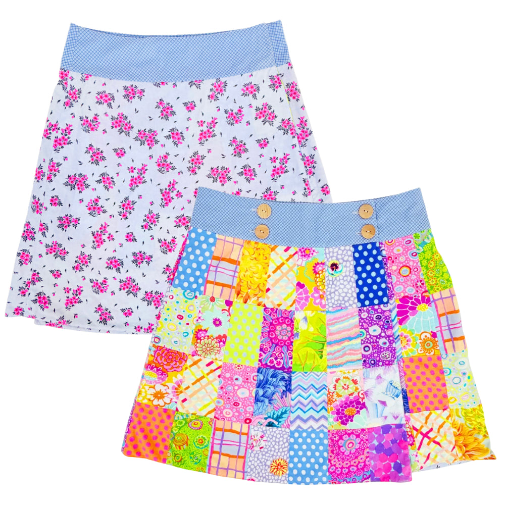 Two girls' skirts shown on a plain white background. The back skirt has a white background with a pink floral print and a light blue waistband.