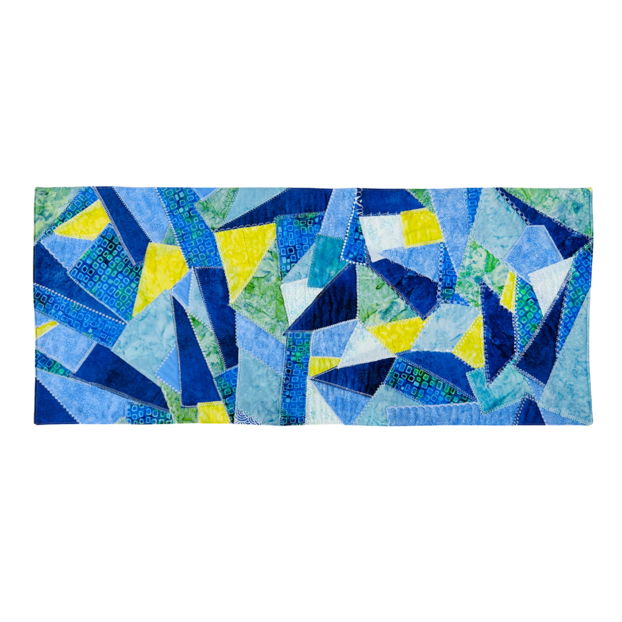 A rectangular patchwork quilt featuring an abstract geometric pattern of blue, navy, light blue, green, and yellow triangles, displayed flat against a solid white background.