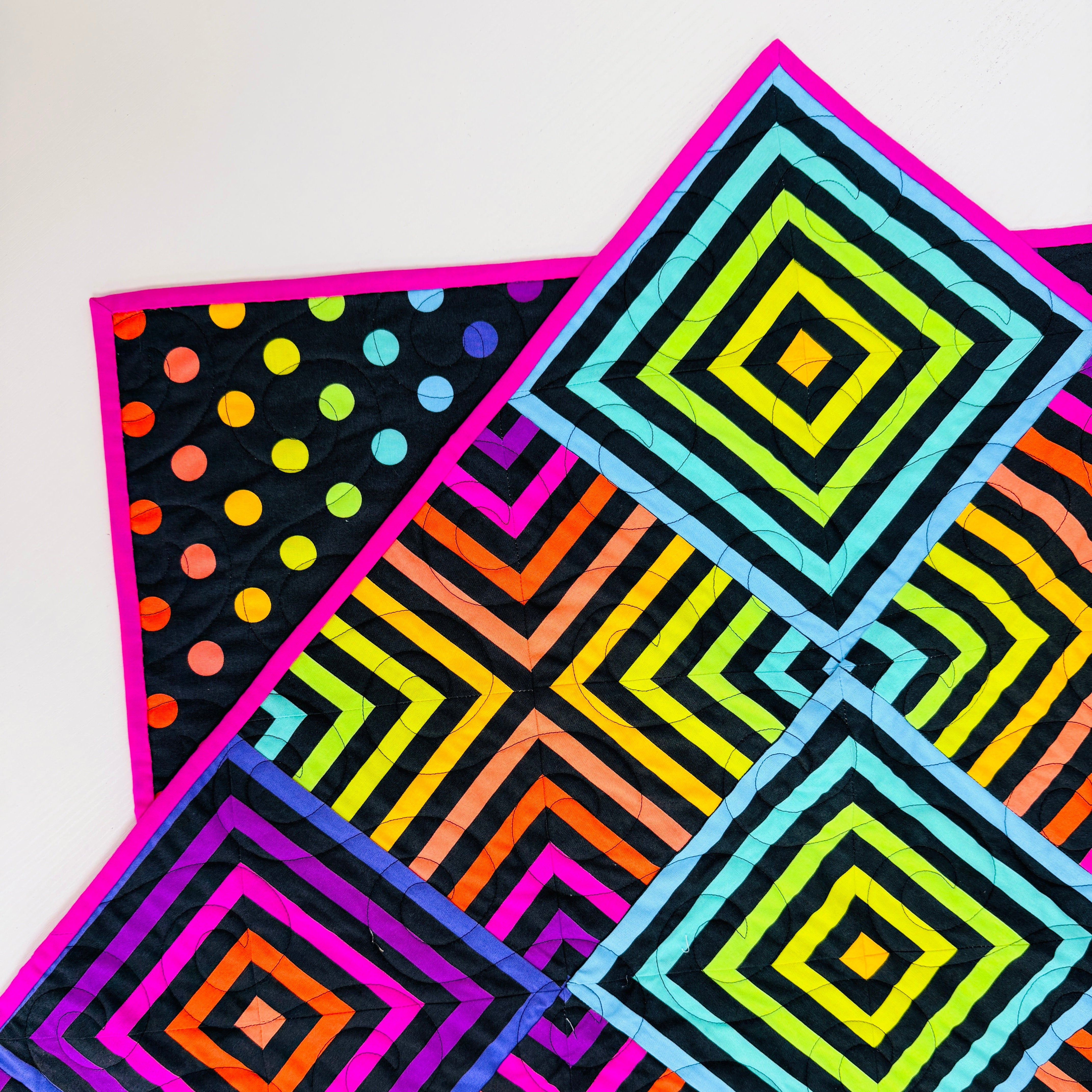 Colorful geometric patterned fabric with squares and polka dots on a white background