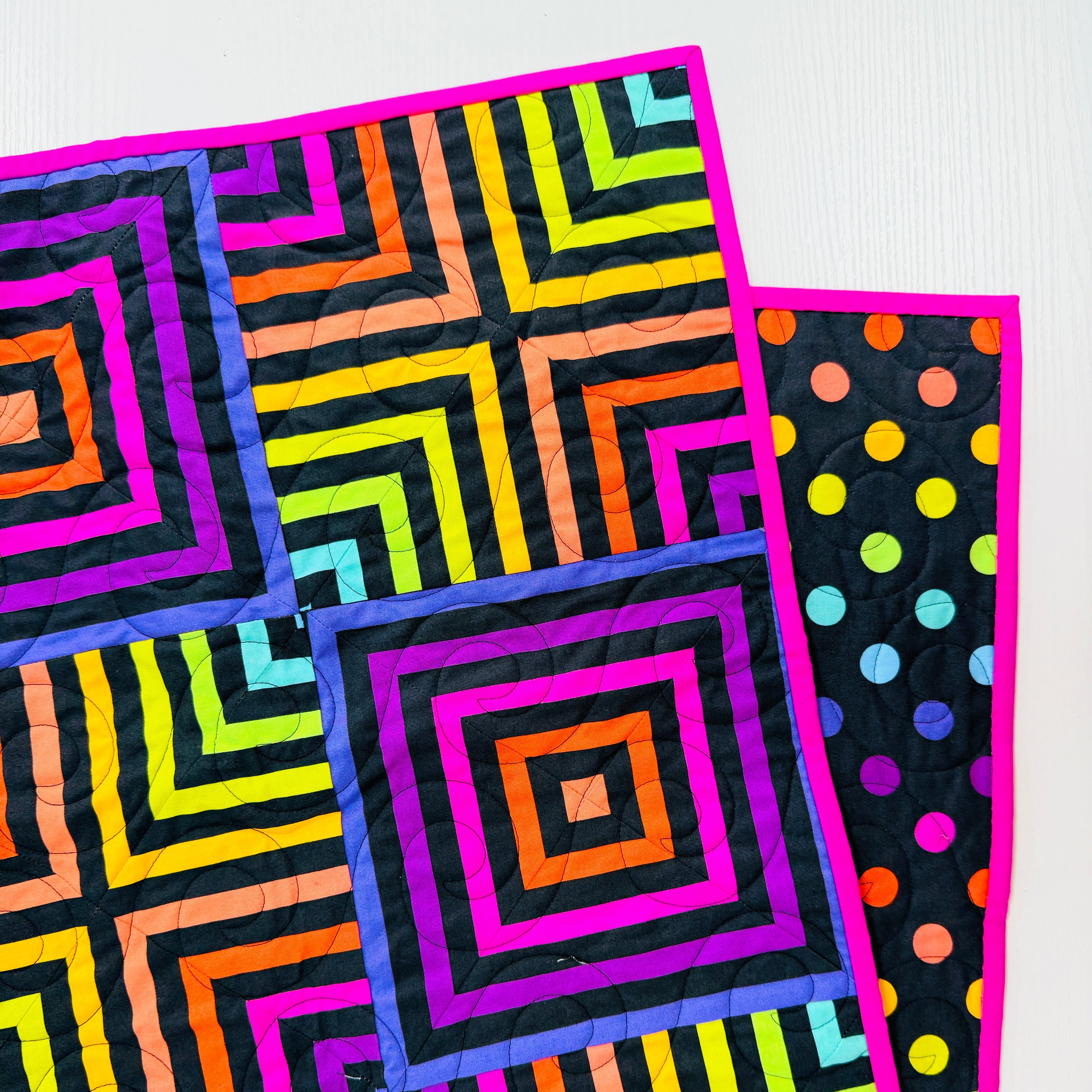Colorful quilt with geometric patterns on a white background