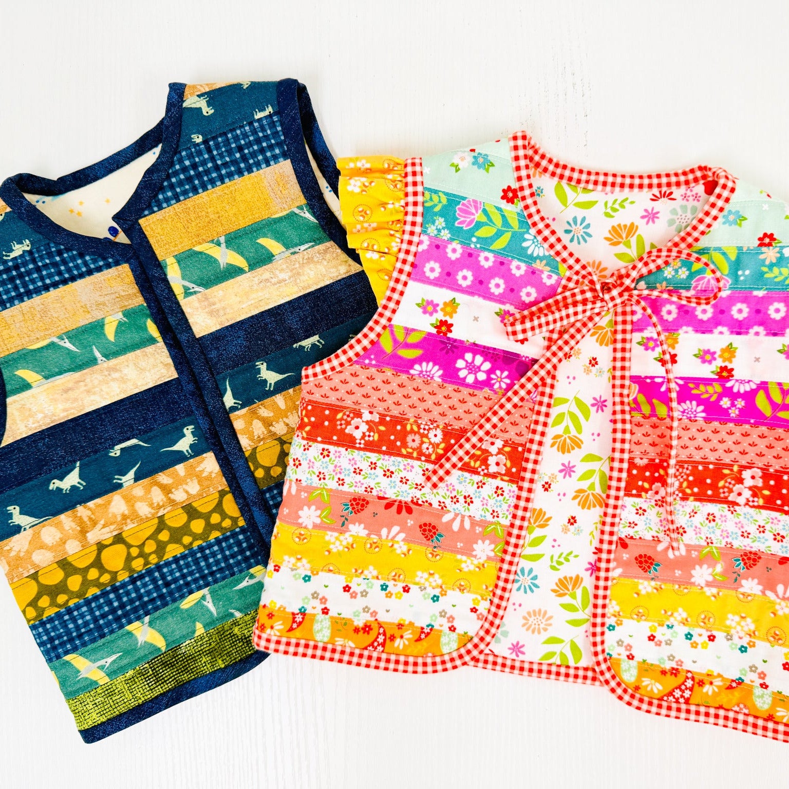 Two sleeveless quilted vests laid flat on a white background. The vest on the left has horizontal stripes in navy, teal, yellow, and cream with bird motifs.