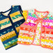 Two sleeveless quilted vests laid flat on a white background. The vest on the left has horizontal stripes in navy, teal, yellow, and cream with bird motifs.