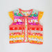 A colorful baby vest with a patchwork floral print, red gingham trim, ruffled sleeves, and a front tie closure, laid flat on a white background.