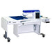 A white, height adjustable sewing table with an electric lift and a filler panel, equipped with wheels for mobility.
