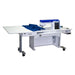 A white, height adjustable sewing table with an electric lift and a filler panel, equipped with wheels for mobility.