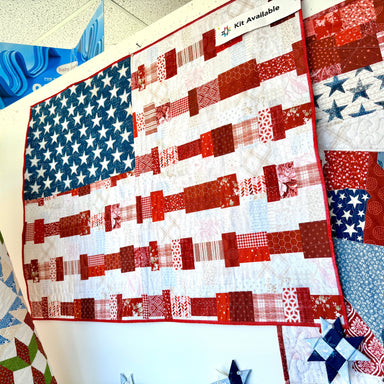 Quilt with American flag pattern displayed on a table.