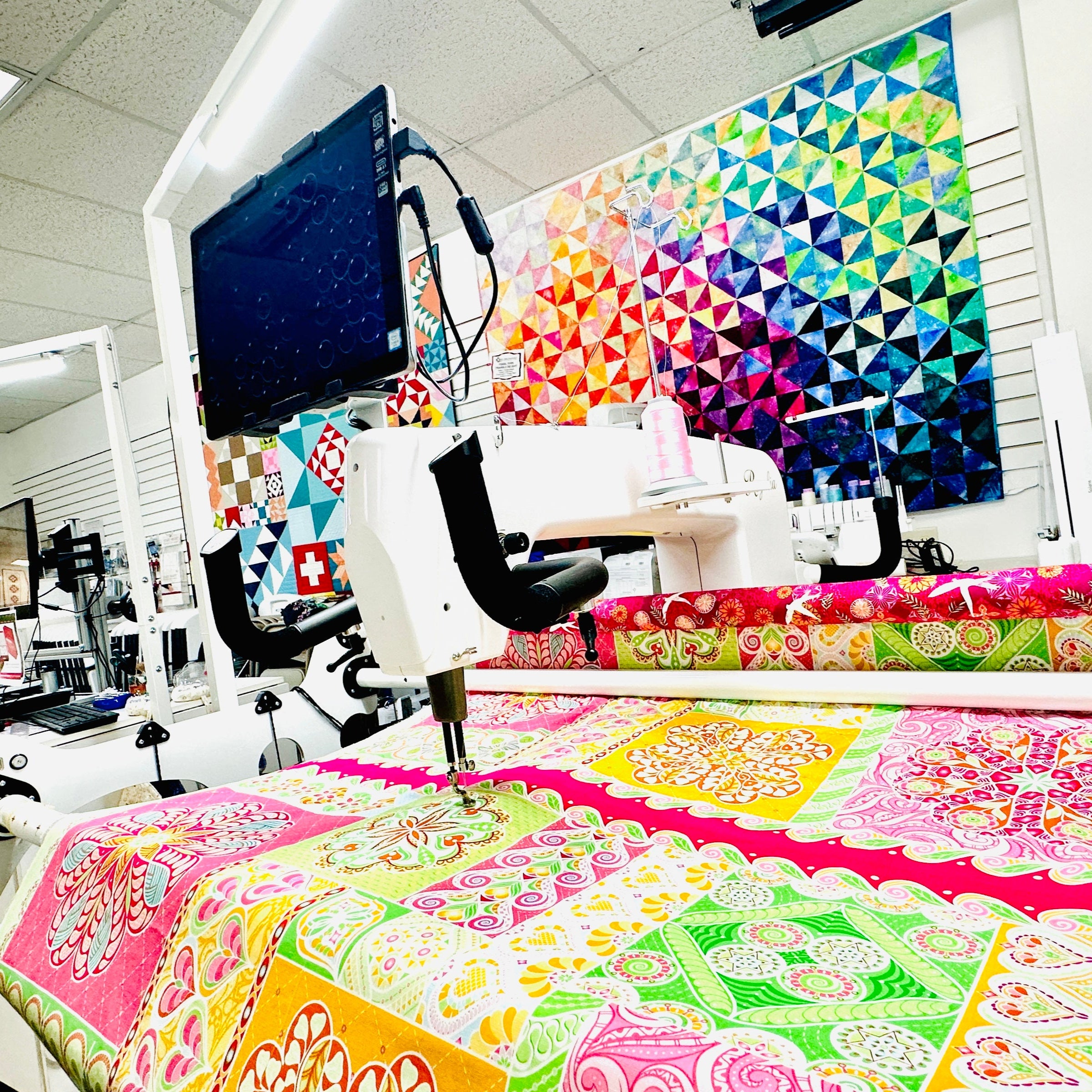 Quilting shop with colorful quilts and Baby Lock longarm Regalia machine
