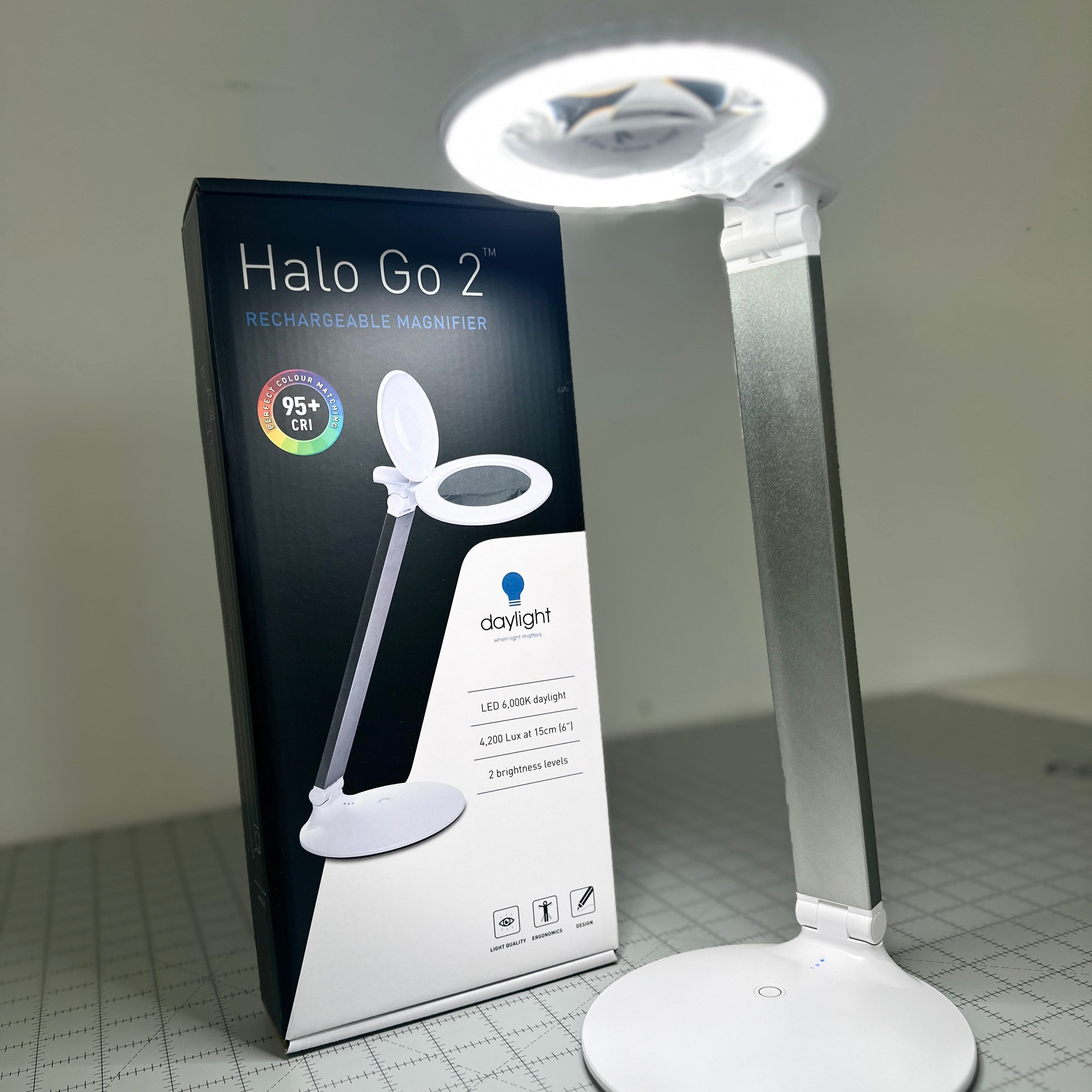 Halo Go 2 LED magnifier lamp with packaging on a grid background