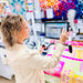 Woman using a computer in a fabric store with colorful quilts in the background