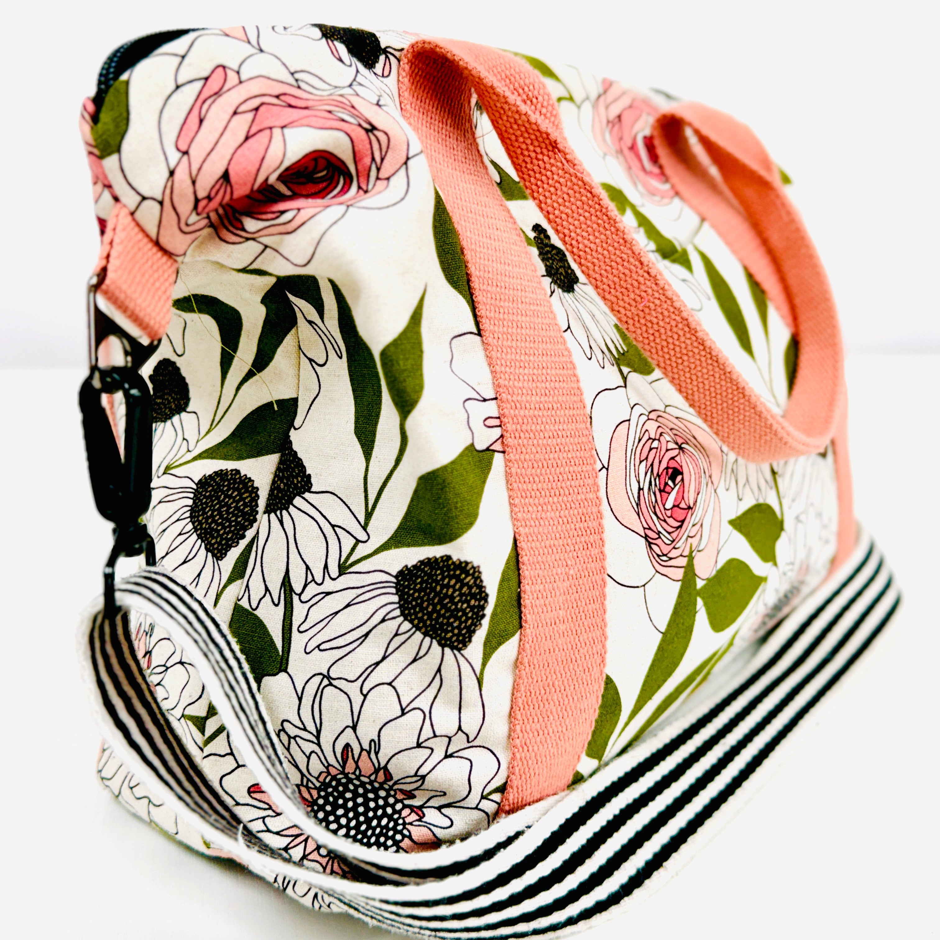 Floral-patterned bag with a pink strap on a white background