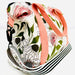 Floral-patterned bag with a pink strap on a white background