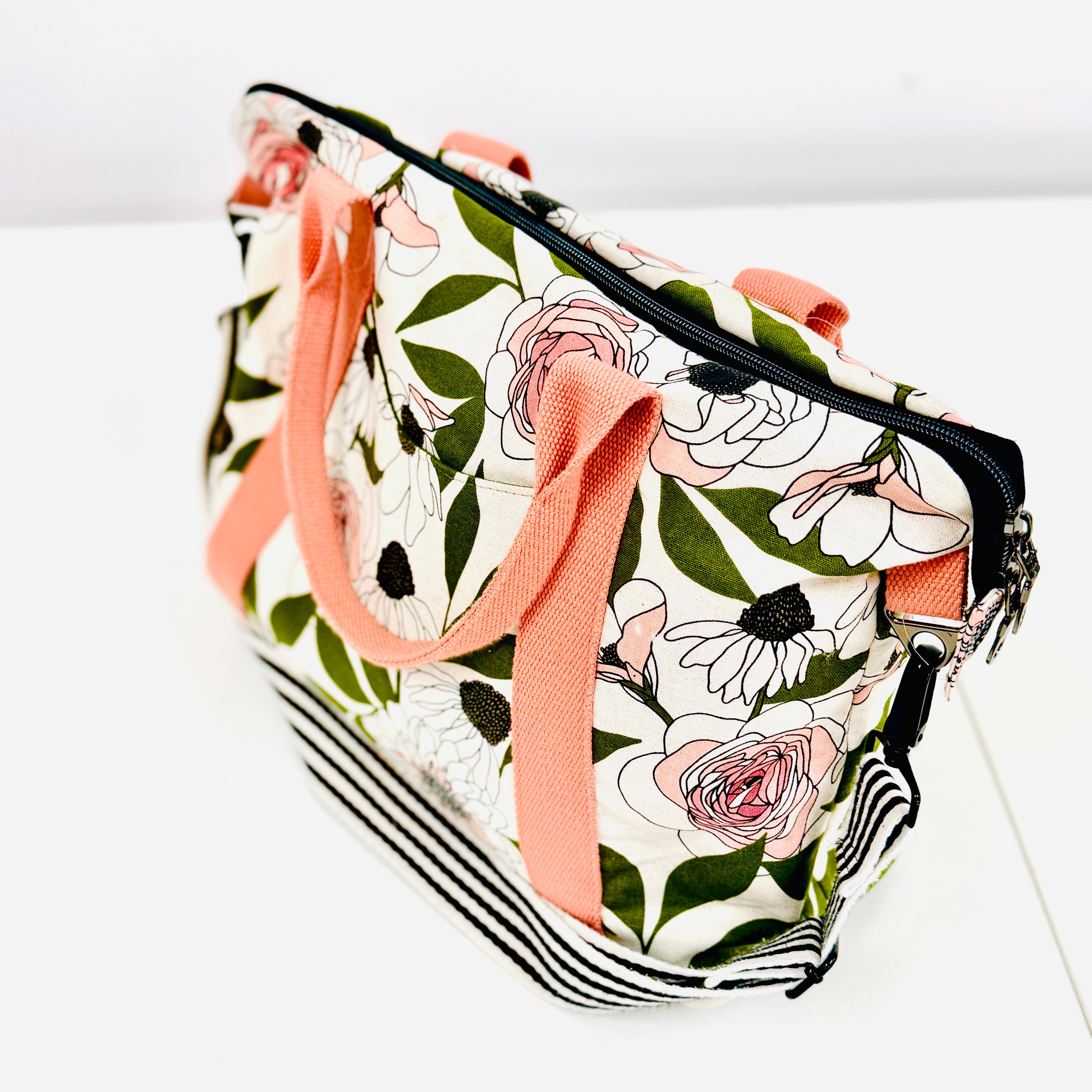 Floral-patterned bag with pink straps on a white background