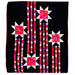 A square quilted textile featuring a black background with four starburst motifs in white and bright pink, red, orange, and purple patterned fabric, connected by vertical striped columns in pink, white, and black.