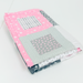 A folded handmade quilted baby blanket with a house design, featuring pink starry fabric, a gray floral patch, and striped details, displayed on a white surface.