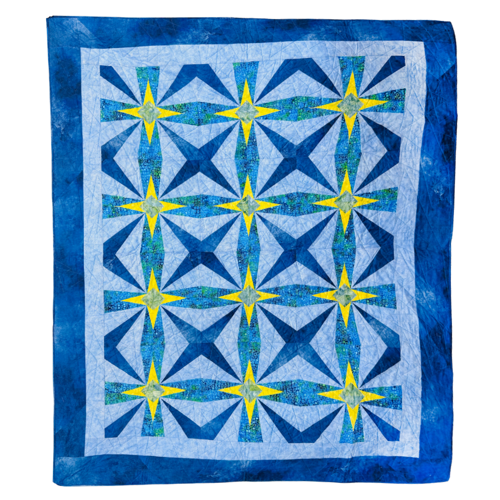 A square quilt with a geometric starburst pattern, featuring shades of blue, navy, and yellow on a white background with a blue border.