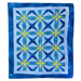 A square quilt with a geometric starburst pattern, featuring shades of blue, navy, and yellow on a white background with a blue border.