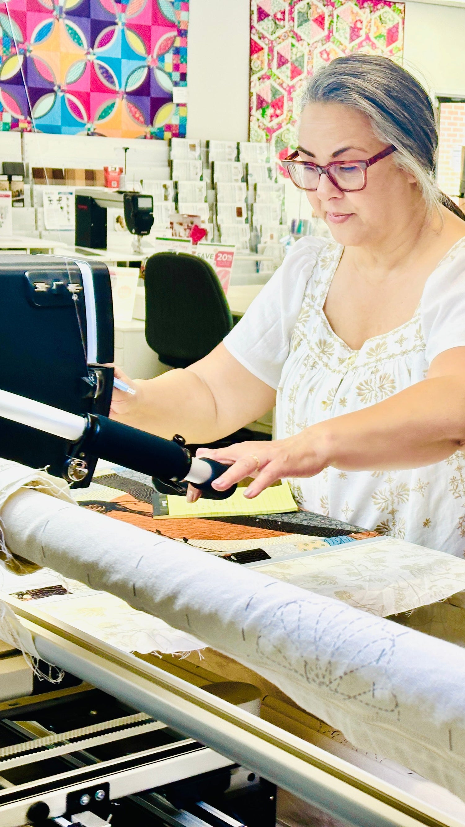 Woman working on a sewing machine in a store setting.