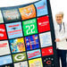 Quilt made from various t-shirts with different designs and text, held by a person.