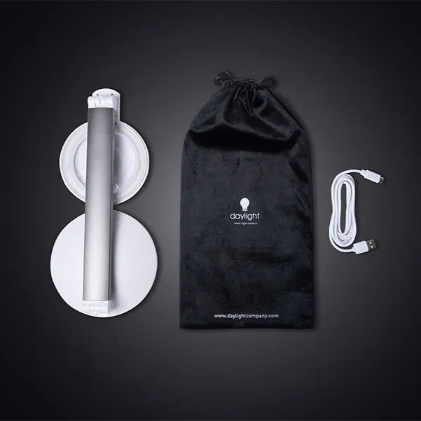 Black drawstring bag with a brand logo, white cylindrical object, and cable on a dark background