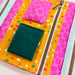 Colorful fabric pouch with a green pocket and pink floral pouch on a white background