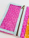 Pink polka dot pouch with a gold zipper on a white background