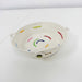 A small woven basket tray made from off-white rope, decorated with colorful embroidered curved lines and small dots in red, green, blue, yellow, and pink, set against a plain white background.