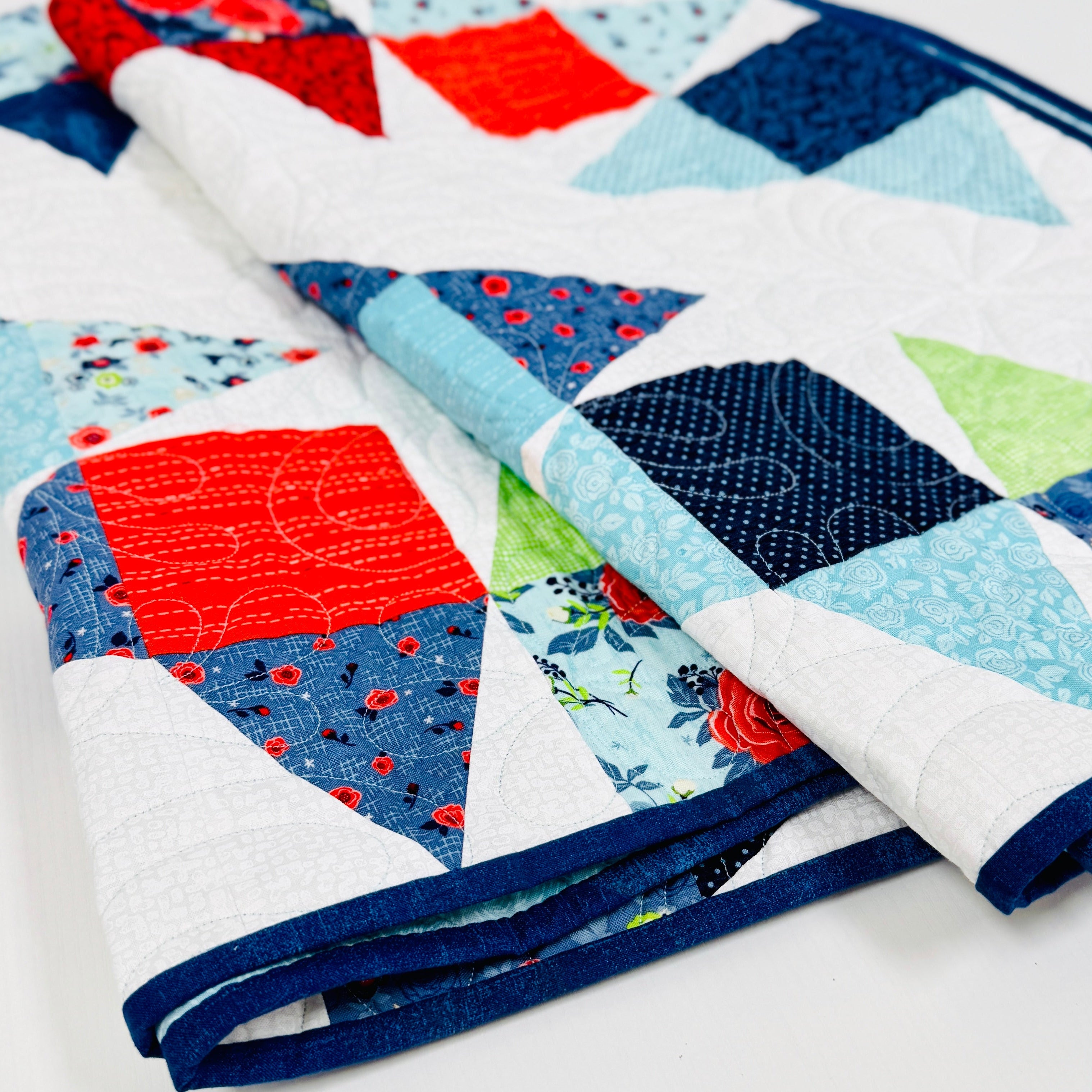 Colorful quilt with geometric patterns on a white background